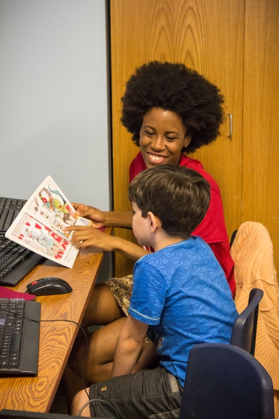 MIT junior Arica Wyche helps Higor Fontoura with reading. MIT students in the ReachOut program tutor children at East End House.