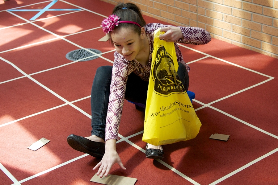 Eighth-grade student Lirianna Valerio of Lawrence, Massachusetts, acts as a "Human Roomba," traversing a grid using pseudo-codes that she and the other students wrote directing her to “pick up dirt.”