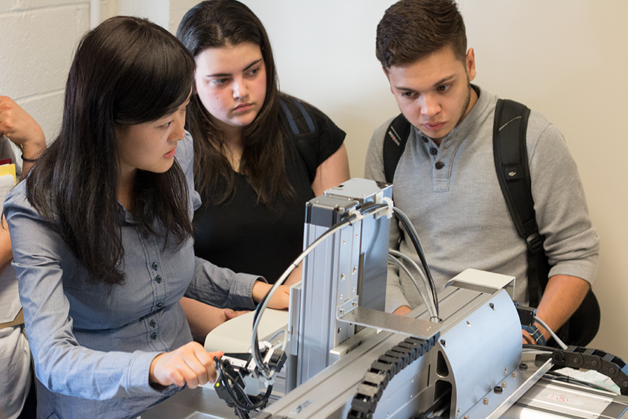 Micro-resolution printing: MIT postdoc Qing Hu demonstrates a 2-D pattern printer with a 30-micron tip while MIT Summer Scholars Mariely Caraballo Santa and Jahzeel Rosado Vega watch in the lab of Professor Nicholas Fang.
