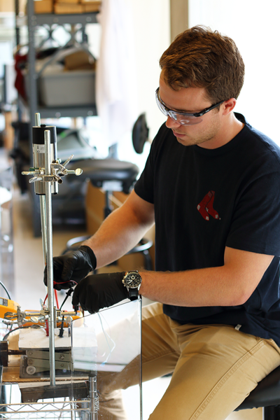 Summer Scholar Stephen Gibbs sets up a one-dimensional thermopower wave experiment to measure the electric output of a fueled carbon nanofiber. As chemical fuel burns across the carbon nanofiber, the temperature difference creates electricity. Gibbs worked on the project in the lab of MIT Professor Michael Strano. They conducted dozens of similar experiments, measuring magnetic field, voltage, tem...
