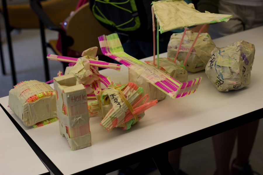 Students built structures to protect an egg from a three-story drop using only straws, tape, and rubber bands.