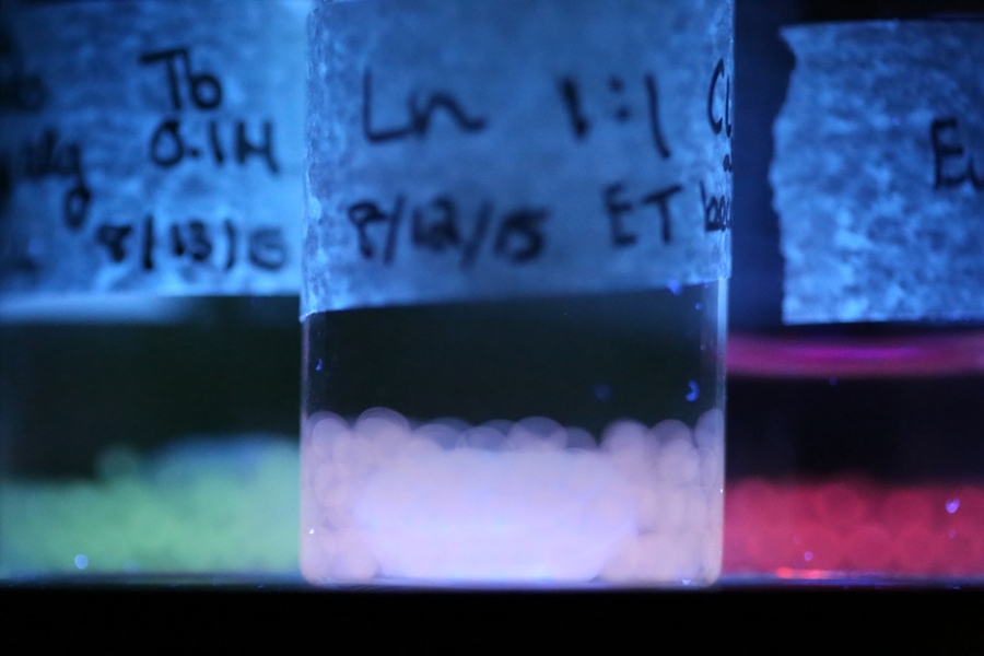 Luminescent materials produced by the MIT team are shown under ultraviolet light, emitting different colors of light that can be modified by their environmental conditions. These light-emitting beads were made by materials science and engineering students Caroline Liu and Rebecca Gallivan. 