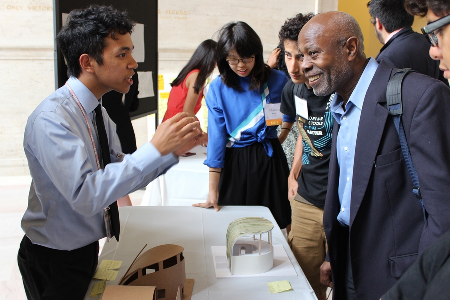 During the 2015 MITES Symposium, MITES student Reynaldo Cabansag (left) of Alexandria, Virginia explains the building he designed in his architecture elective to MIT Professor Cardinal Warde, who is the faculty director for MITES.