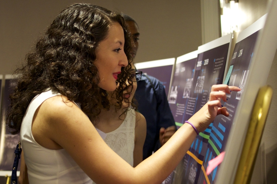 Ximena Hasbach, a MITES 2014 alumna and MIT freshman, peruses a timeline that chronicles the history of MITES since 1975 at the MITES 40th Anniversary Launch Party.