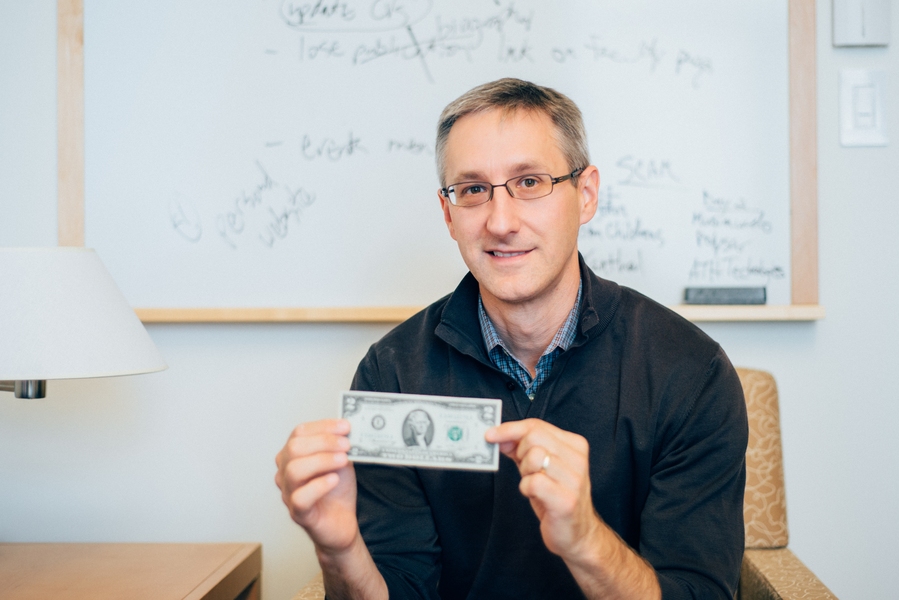 Christopher Noe, a senior lecturer in MIT Sloan, shows off his lucky $2. He appears in a new documentary about the bills. 