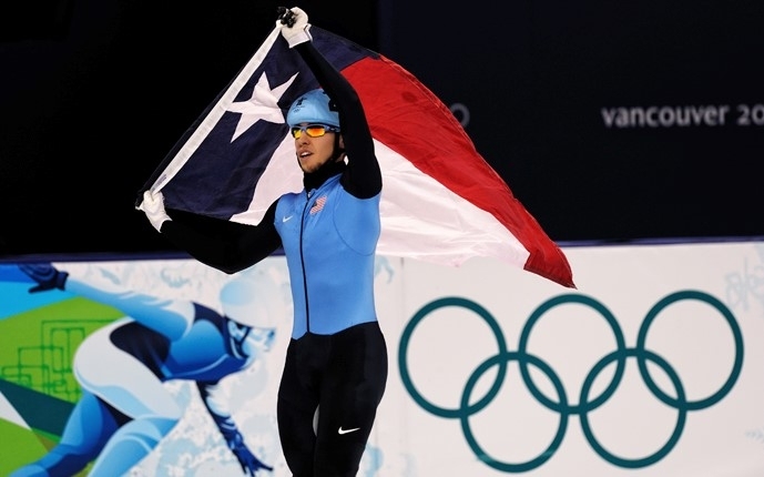 MIT transfer student Jordan Malone takes a victory lap, with the Texas state flag, at the Vancouver Olympics in 2012