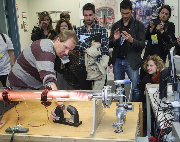 Bob Mumgaard demonstrates how the plasma in a glow discharge tube responds to magnetic fields. Fusion devices like MIT’s Alcator C-Mod tokamak use magnets to keep hot plasma contained and away from the walls of the device.