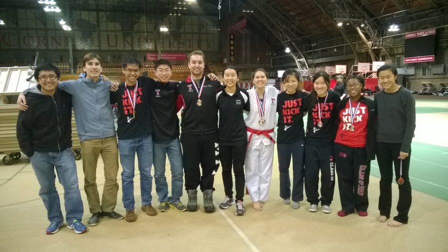 Eleven people pose for portrait inside Cornell University gymnasium