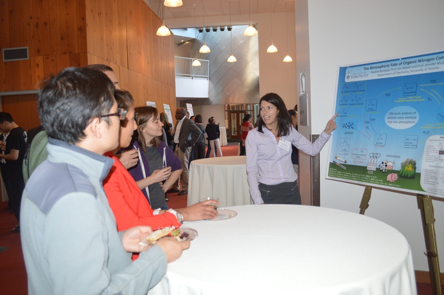 Four people surround a presenter with poster