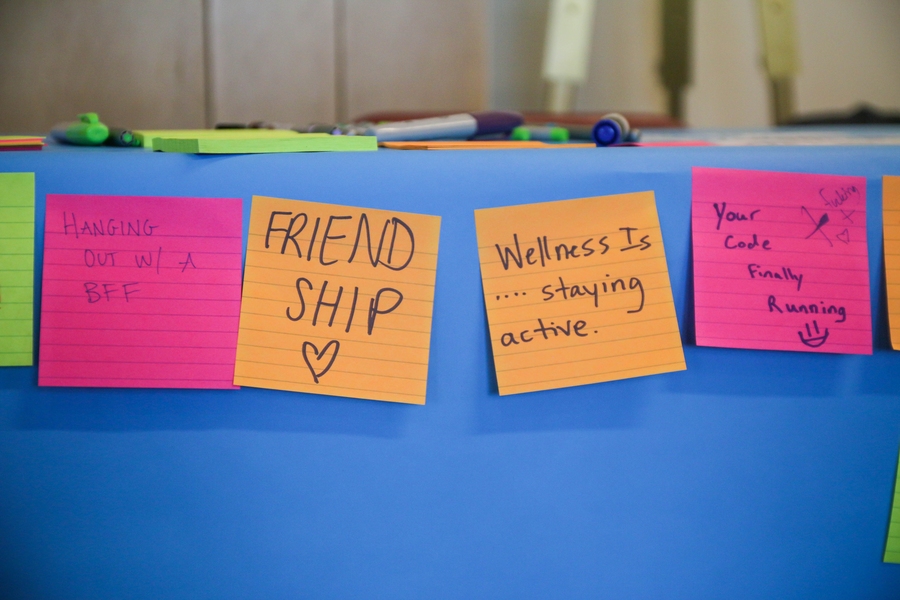 Post-its on a Division of Student Life Wellness Fair station answer what balance, wellness, success, and happiness mean to students. 