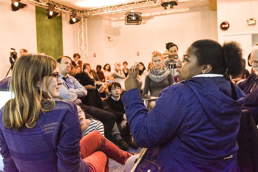 Thango of South Africa (foreground right), representing developing nations in the World Climate role-play, negotiates for financial and technological aid from developed nations. She discusses the climate issues developing nations face with her fellow delegates.
