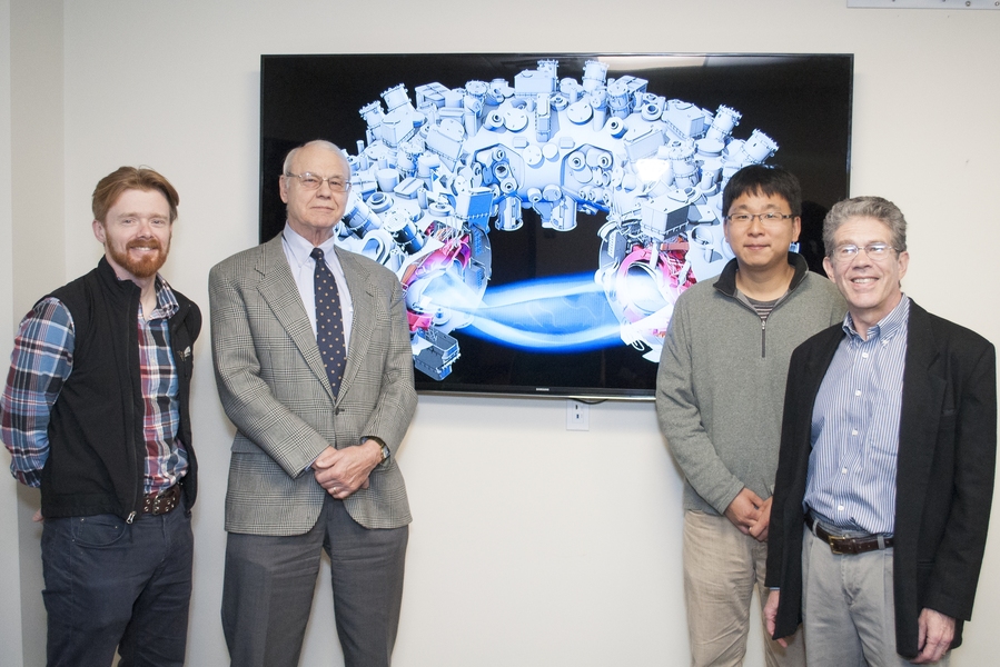 MIT collaborators (l-r) Eric Edlund, Professor Miklos Porkolab, Seung-Gyou Baek, and Jim Terry flank a graphic of the new Wendelstein 7-X stellarator.