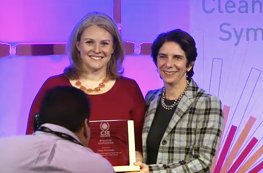 Grace Overlander (left) accepts her award from Lisa Frantzis, senior vice president of strategy and corporate development at Advanced Energy Economy, at the C3E Women in Clean Energy Symposium.