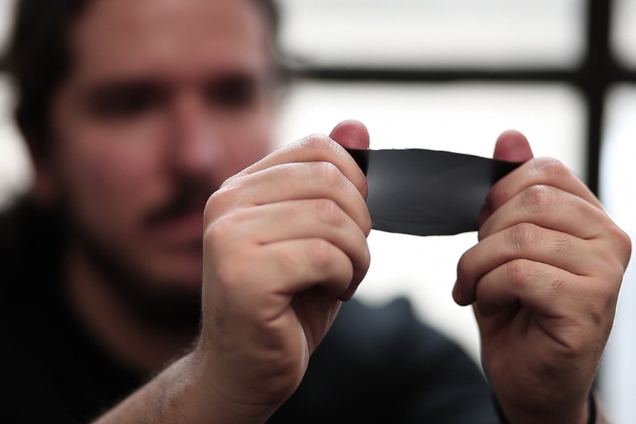 MIT postdoc Francisco López Jiménez stretches a rectangular sheet of the polymer PDMS he and his colleagues used to predict how much light is transmitted when a specific mechanical force is applied.