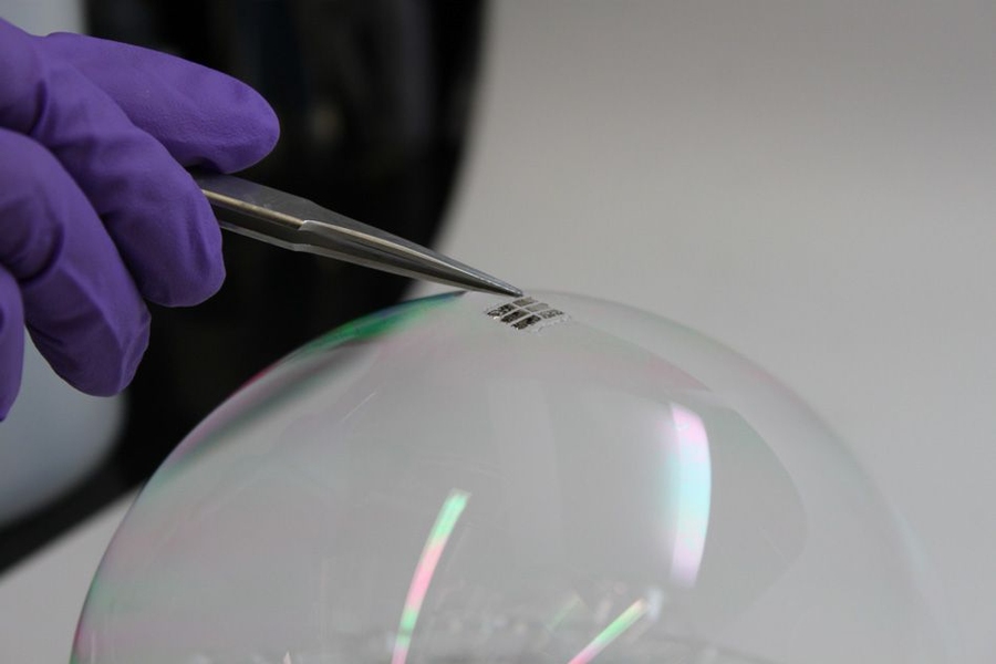 The MIT team has achieved the thinnest and lightest complete solar cells ever made, they say. To demonstrate just how thin and lightweight the cells are, the researchers draped a working cell on top of a soap bubble, without popping the bubble.
