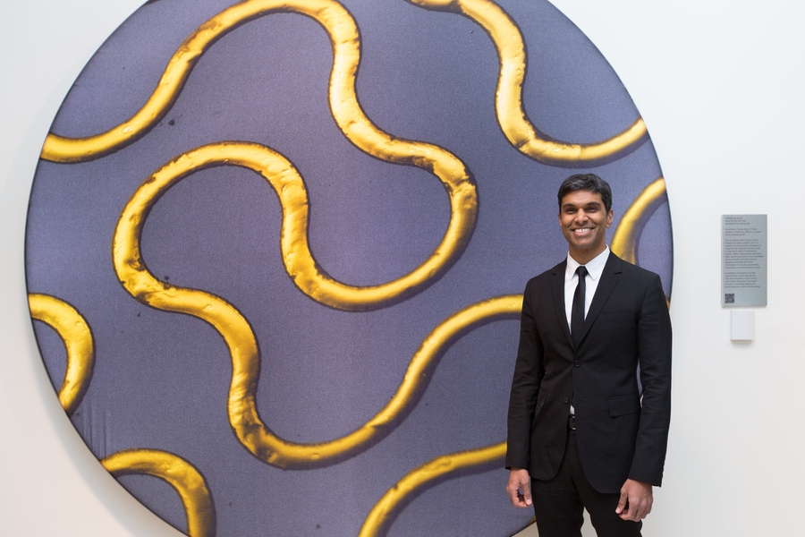 Omar Khan, from the Anderson and Langer laboratories, stands with image award winner “Nerves of Gold: New Potential for Regenerative Medicine.”