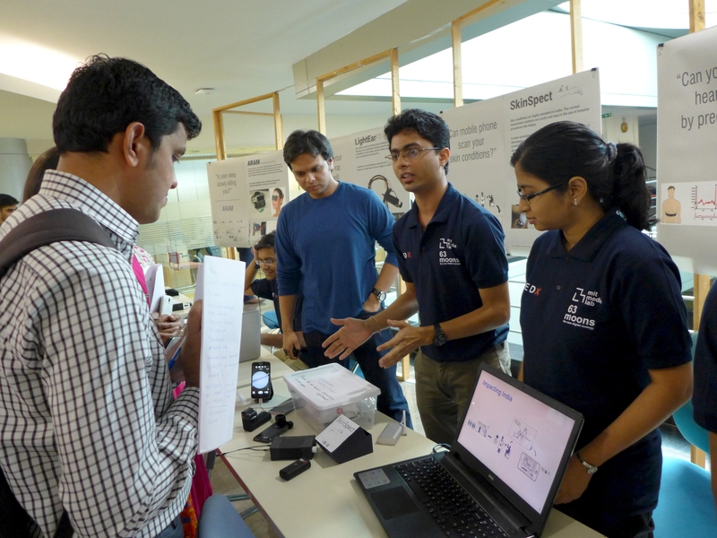 Students from Emerging Worlds Mumbai showcase their projects as Tata Center postdoc Anshuman Das (center, in blue) looks on.