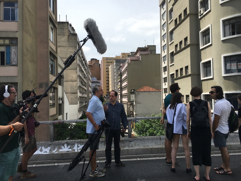 A documentary film crew engages visiting professor Angelo Bucci and students as they visit their study site, the Minhocão elevated highway that runs through São Paulo.