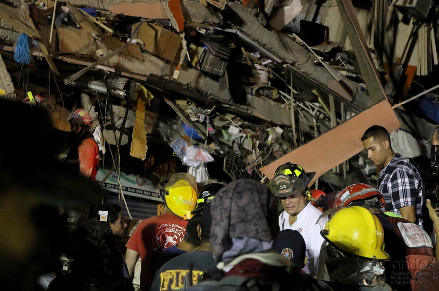 Emergency workers confer in the wake of destruction caused by the April 16 earthquake.