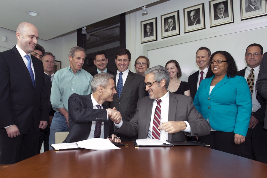 Lockheed Martin CTO Keoki Jackson '89, SM '92, ScD '97 (center, left) and MIT AeroAstro department head Jaime Peraire congratulate each other after signing a research collaboration agreement between the two organizations. Initial research will focus on robotics and autonomous systems.