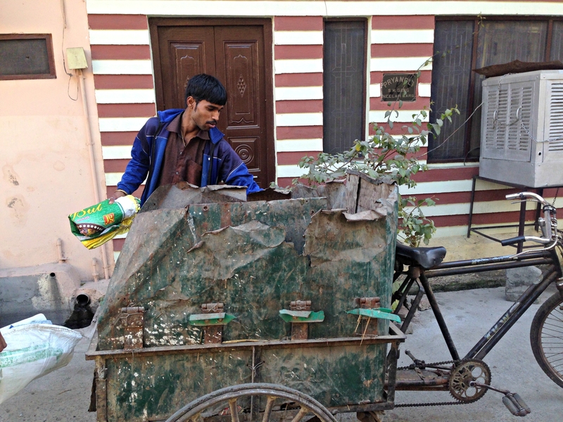 A waste collector in Muzaffarnagar loads his tricycle cart. Hundreds such collectors go door-to-door picking up household waste every day.