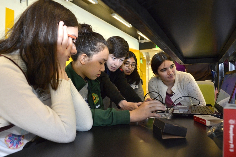 A volunteer from MIT Lincoln Laboratory (center) helps students program Instagram-style filters.
