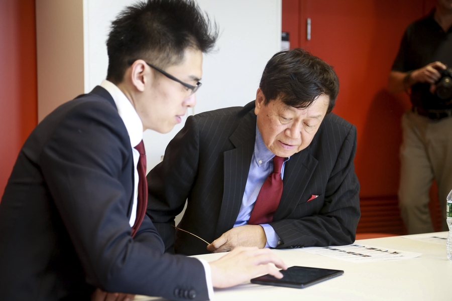 MIT alumnus Samuel Tak Lee (right), whose generous 2015 gift made the renovations possible, toured the building on the day of the reopening celebration to see the renovations and met with students and faculty in the Samuel Tak Lee MIT Real Estate Entrepreneurship Lab. Here, he watches a demonstration by Jintai Li, a second-year graduate student in urban studies and planning and the recipient Samue...