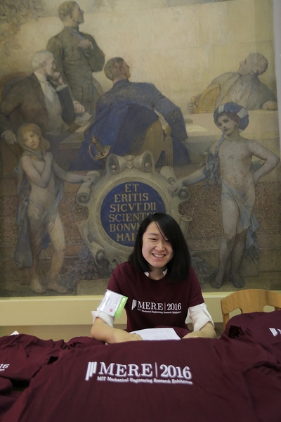 Master's student Menglei Jiang hands out shirts at the 3rd annual Mechanical Engineering Research Exhibition (MERE).