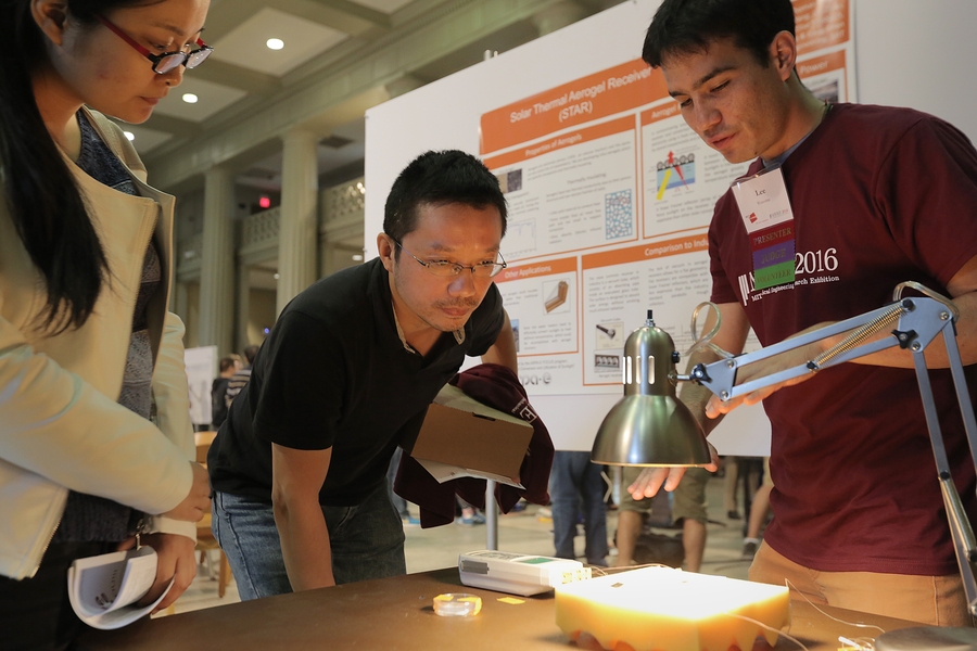 Jinghui Miao (left) and Xian Du (center) listen to PhD student Lee Weinstein's presentation on solar thermal aerogel receivers.