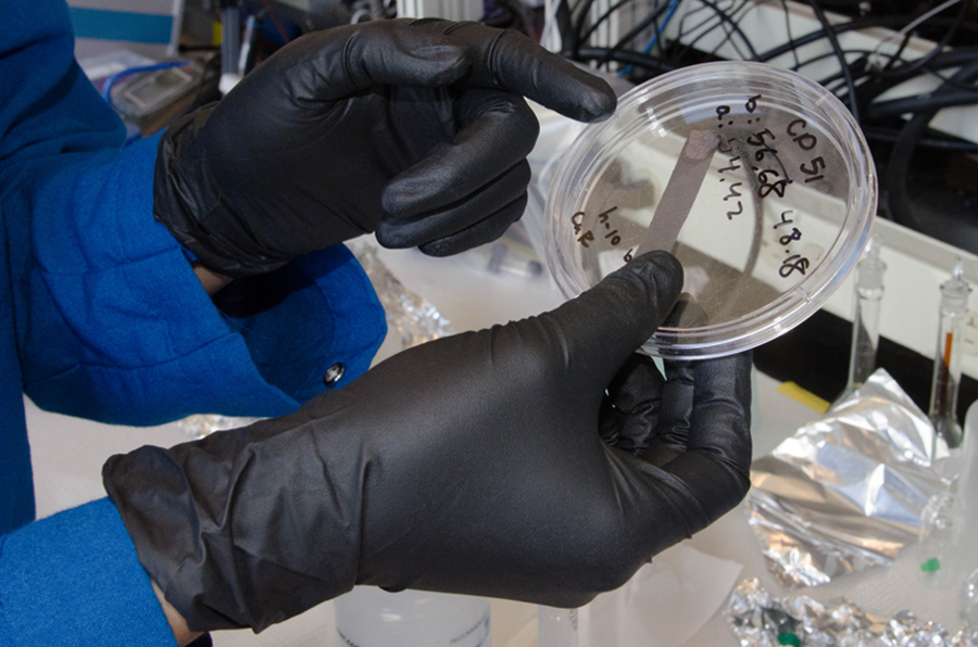 Yao holds a container with a thin electrode made of carbon with a copper hexacyanoferrate-type (Prussian blue) active area at the top end.