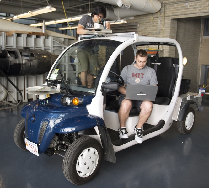 MIT junior Wally Wibowo (left) and graduate student Justin Miller prepare an electric vehicle for the Aerospace Controls Lab mobility-on-demand research.