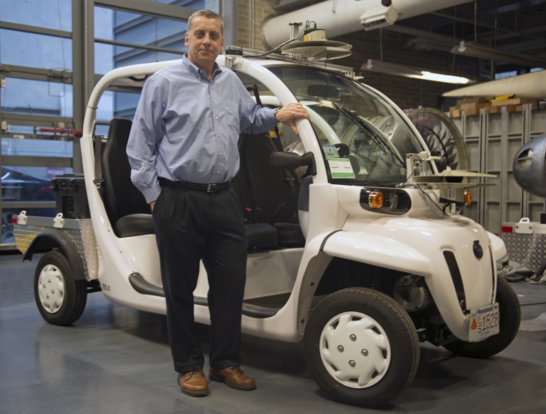 Aerospace Controls Lab director Jonathan How with one of the vehicles his lab will use to develop protocols for mobility-on-demand shuttle services.