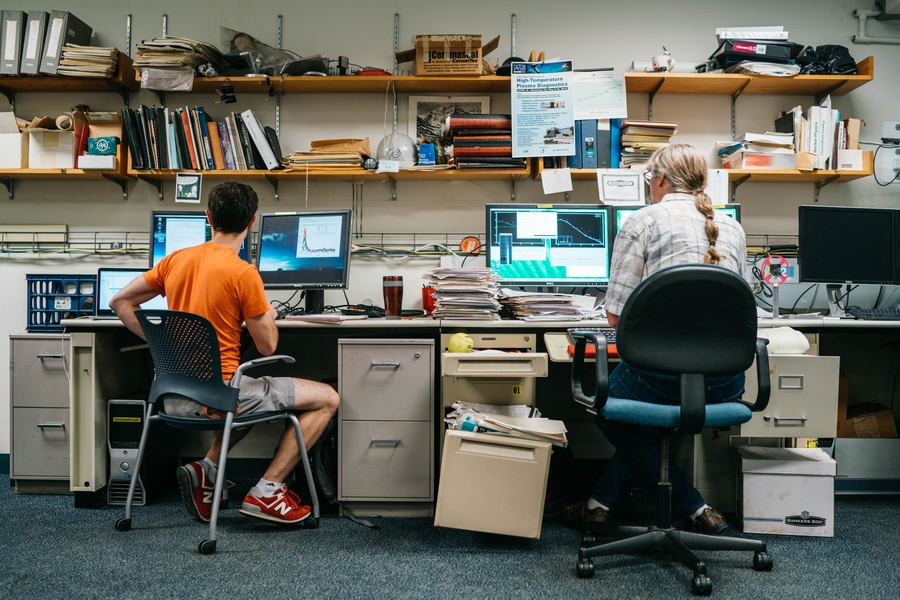 Alex Creely (left), a graduate student in the Department of Nuclear Science and Engineering, and Senior Research Scientist John Rice focus on their work in a busy control room just a week before the shutdown.