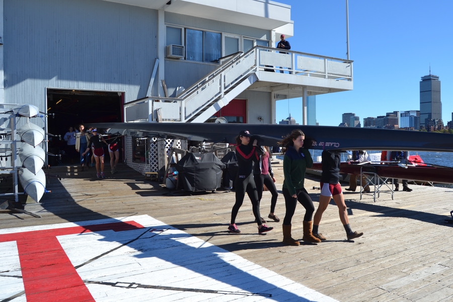 Members of the Varsity 8 lineup prepare for race time. Valerie Hunter (front left) and Kelly Barton carry bow 39, a 200-pound boat, with help from Michelle Lauer (back left) and Sylvia Sarnik. Navigating the shell across the busy dock isn’t easy but directives like, “Ready up in the bow, swing to Boston,” get the job done.