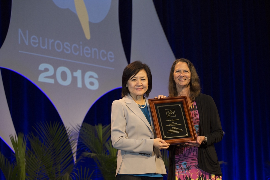 MIT neuroscientist Li-Huei Tsai (left) receives the Mika Salpeter Lifetime Achievement Award from Society for Neuroscience President Hollis Cline.