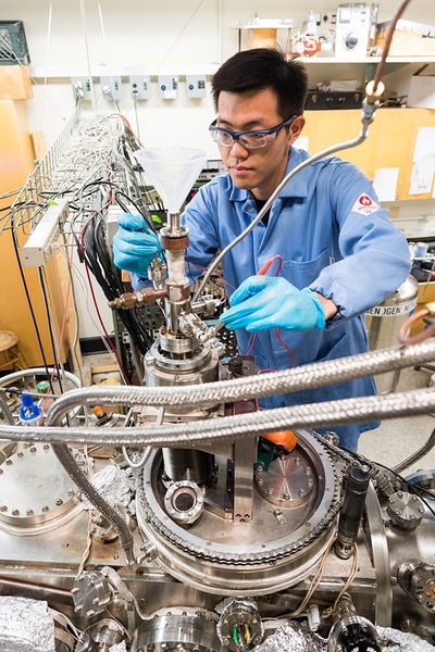 Graduate student Qing Liu of chemistry prepares for an experiment examining fundamental chemical reactions that occur on a crystal designed to catalyze fuel gasification in a Fischer-Tropsch system. Here he performs a routine check of the connection between the thermocouple leads and the sample crystal to ensure reliable readings of reaction temperatures during the tests.