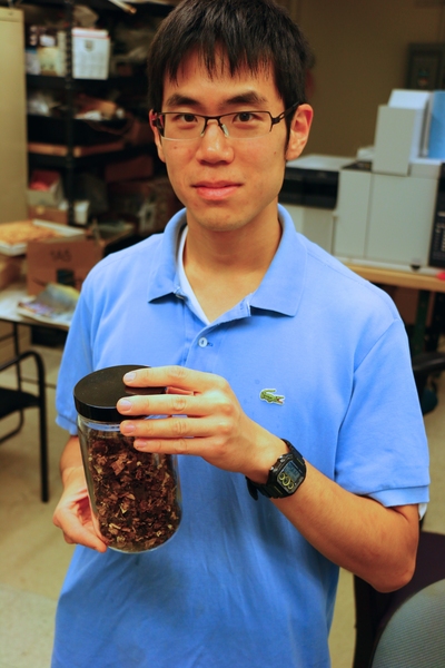Tata Fellow Kevin Kung displays a jar of torrefied biomass — agricultural waste that has undergone thermochemical treatment in the torrefaction reactor to increase its energy density.