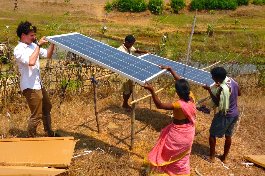 Kevin Patrick Simon (left) sets solar panels in place with villagers at a pilot site in Jharkhand, India. Simon, an MIT PhD candidate in mechanical engineering, is studying solar irrigation. 