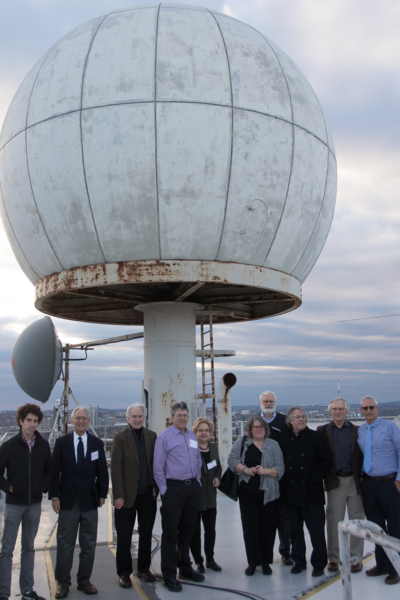 Pauline M. Austin Day attendees pose in front of the radomes on the Green Building.