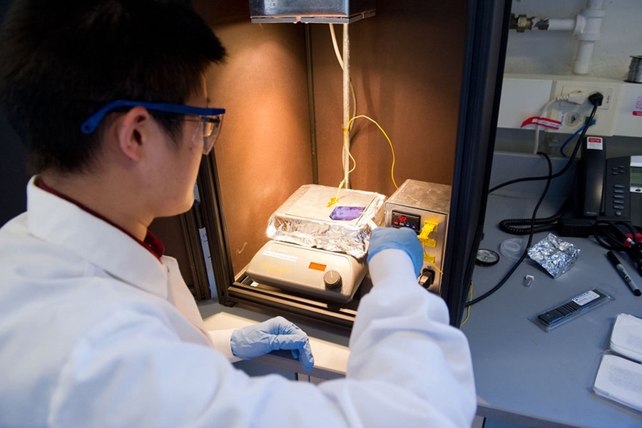 Postdoc Ashley Morishige prepares to use a halogen lamp to “light-soak” a silicon wafer extracted from a PERC solar cell. The procedure is designed to induce the faults that have been causing the power output of some PERC modules to decline in sunlight.