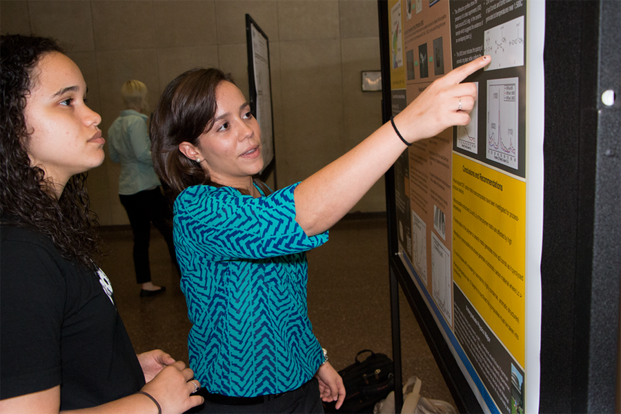 Summer Scholar Naomi Morales (right) discusses her research project at an August 2014 poster session with materials science and engineering alumna Mackenzie Devoe ’15. Both contributed to a paper led by postdoc Itai Stein that was published in the journal Carbon.  
