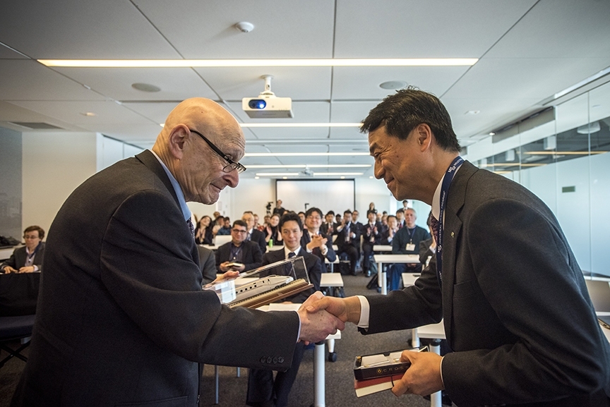 Tako Nishiyama, executive director of JR East, exchanges gifts with Professor Joseph Sussman. Sussman was the first JR East Professor, which was established in 1991 when the partnership between MIT and JR East began. JR East and MIT recently celebrated 25 years of the partnership.