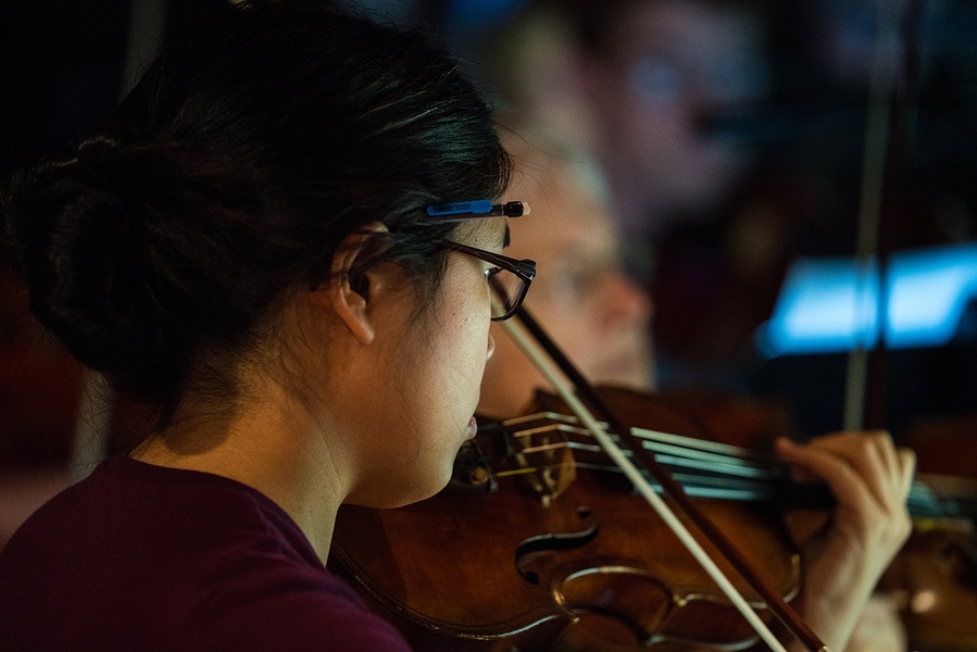 Concertmaster Rossana Chung, a technical associate at the McGovern Institute for Brain Research at MIT, practices for opening night.