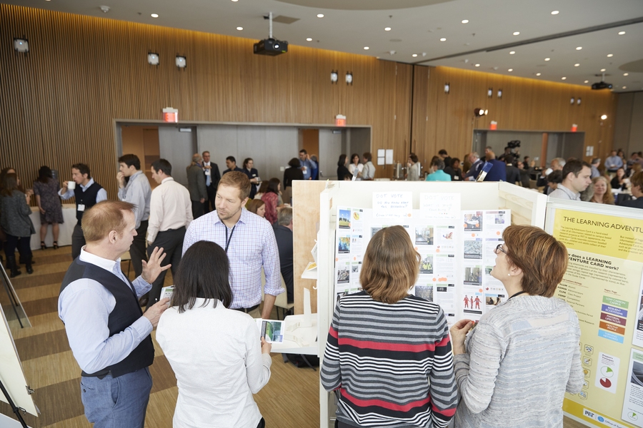 Paul Wolff of MITOS engages participants in a conversation around 'Living Lab' adventure cards, which detail projects such as MIT’s solar farm. Each card outlines the research themes, methods, and outcomes for 'Living Lab' projects at MIT.