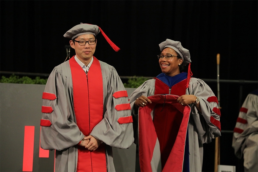 The doctoral hoods are part of the doctoral robe ensemble. After the remarks by Barnhart and Su, all doctoral graduates had their names announced as they walked across the stage, then individually had the hoods draped on their ensembles by their department or program heads.