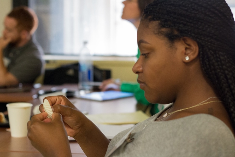 Summer Scholar Kaila Holloway looks over a 3-D printed gear from the lab of associate professor of mechanical engineering John Hart.
