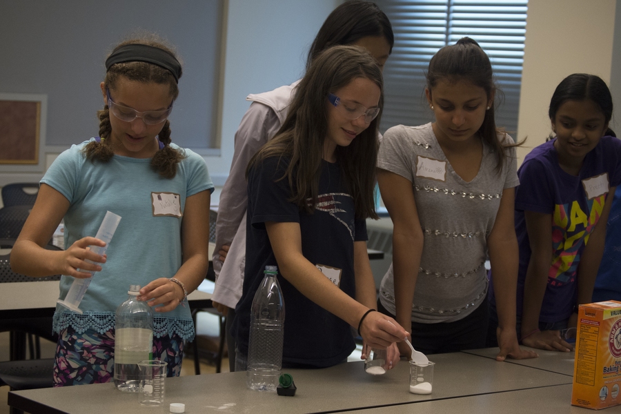 Participants measure baking soda to produce carbon dioxide in order to investigate the greenhouse effect.