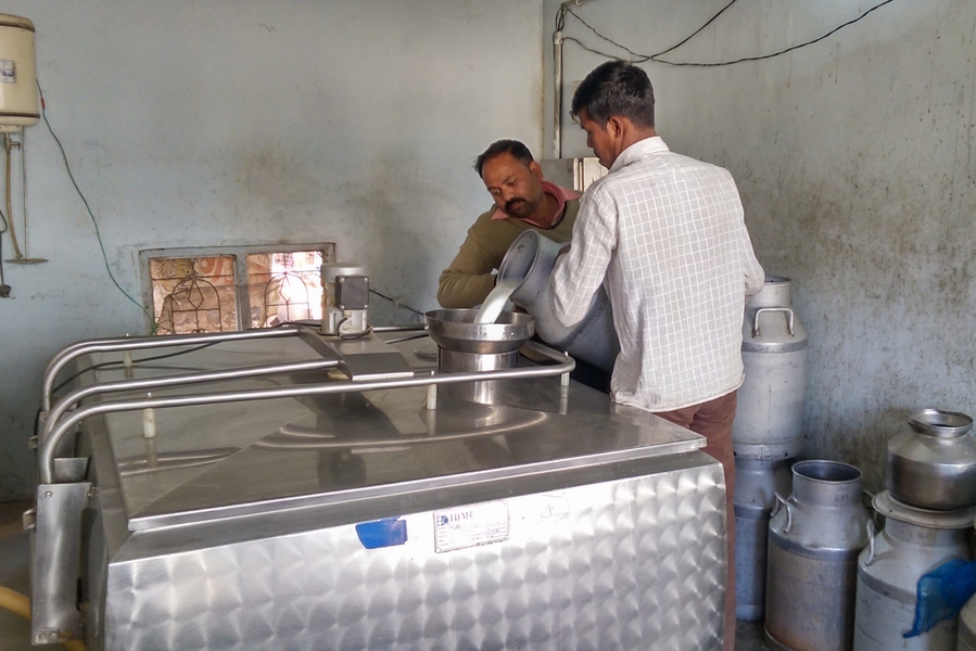 A dairy farmer and collection operator pour milk at a collection center in Village Navli, Maharashtra, India. Technology being developed by Professor Sanjay Sarma and his lab, funded by a J-WAFS Solutions grant, will allow users at village-level milk collection centers such as this one to test their product to ensure quality and nutritional consistency.