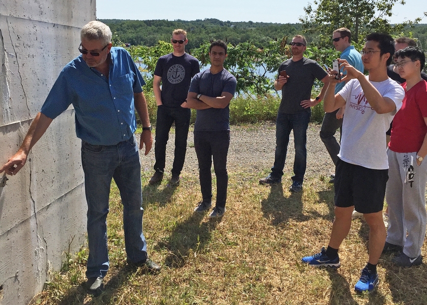 Edmond Zhou (right), a researcher with the MIT Concrete Sustainability Hub and MIT grad student in physics, takes a picture of at a test site set up by research collaborators from the University of New Brunswick near the Mactaquac Dam.
