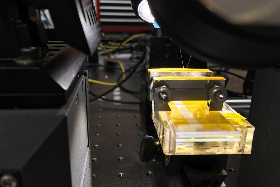 A view of the lab setup that was used to test the new materials, demonstrating that they could be stretched and flexed without losing the ability to confine light beams and carry out photonic processing.